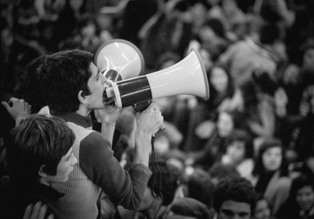 Jovem com megafone no 25 de Abril de 1974. Foto de Alfredo Cunha.